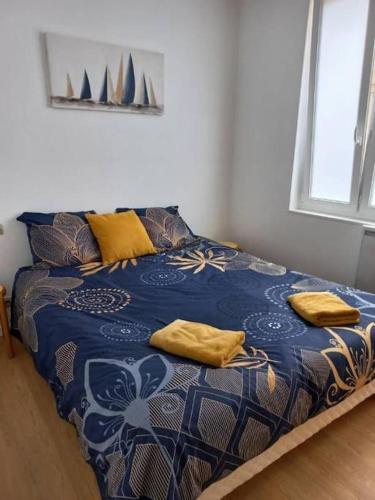 - un lit avec des oreillers jaunes dans l'établissement entre plage et palais, à Fécamp