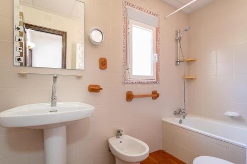 ein Badezimmer mit einem Waschbecken, einem WC und einem Spiegel in der Unterkunft Bungalow Calle Altea in Aigues