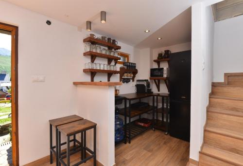a room with white walls and a stairway with a wooden table at Chalupa Daniel in Ždiar