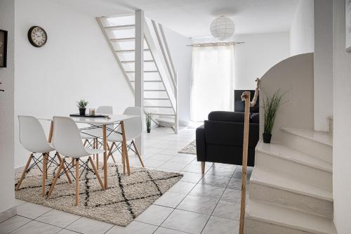 ein Wohnzimmer mit einem Tisch und Stühlen in der Unterkunft Le Beauvoir in Saint-Marcellin