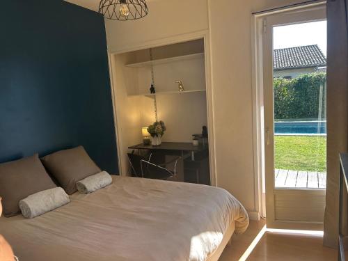 a bedroom with a bed and a desk and a window at la petite bulle in Montagnat