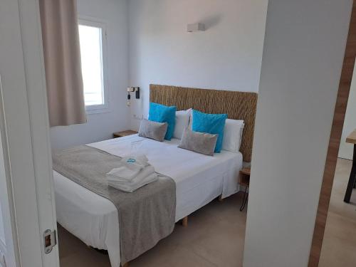 1 dormitorio con cama blanca y almohadas azules en Bamblue Boutique Apartments, en Pineda de Mar