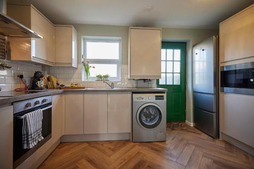a kitchen with a washing machine and a dishwasher at Fairburn - DayDream Stays, luxury accomodation for holidays and contractors in Fairburn