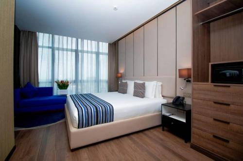 pokój hotelowy z łóżkiem i niebieską kanapą w obiekcie CIKA GOLDEN HOTEL and SUITES w mieście Lomé