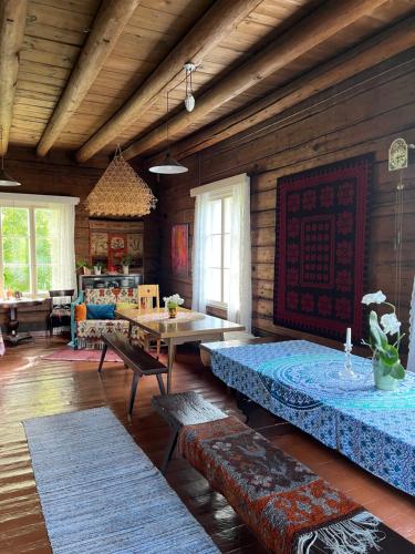 a living room with two beds and a table at Valkolan kartano, vanha tupa in Hankasalmi