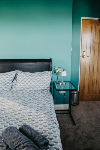 a bedroom with a white bed and a blue wall at Flat Iron Anfield in Liverpool