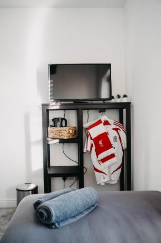 a bedroom with a tv and a bed with a pillow at Flat Iron Anfield in Liverpool