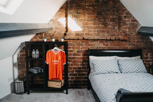 Schlafzimmer mit Ziegelwand und Bett in der Unterkunft Flat Iron Anfield in Liverpool