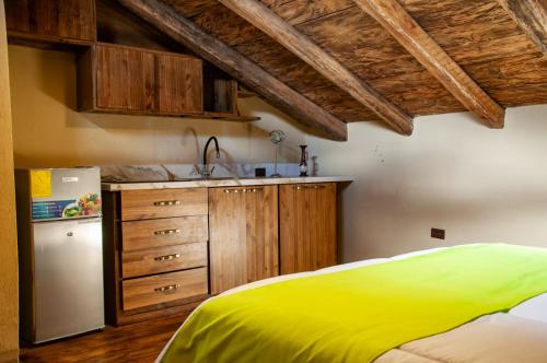 uma cozinha com uma cama amarela e um frigorífico em Casa Suite Campana em Cuenca