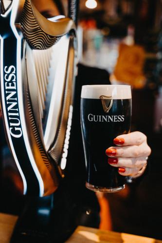 a woman is holding a glass of beer at Flat Iron Anfield in Liverpool