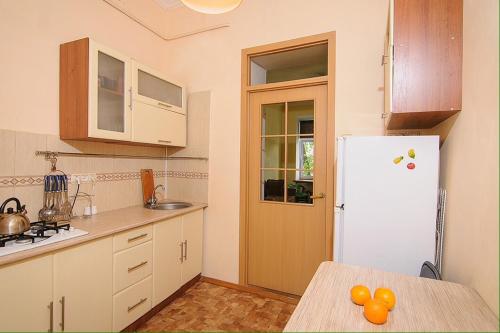 Il comprend une cuisine équipée d'un réfrigérateur et d'une table avec des oranges. dans l'établissement Luxury Apartment near Rynok Square, à Lviv