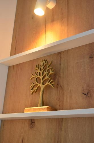ein goldener Baumschmuck auf einem Holzregal in der Unterkunft KooKai - Luxury Living in Peraia