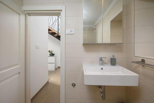 y baño con lavabo blanco y espejo. en House Leny by IstriaLux, en Štokovci