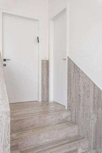 a hallway with two white doors and wooden floors at Beautiful studio in Antwerp