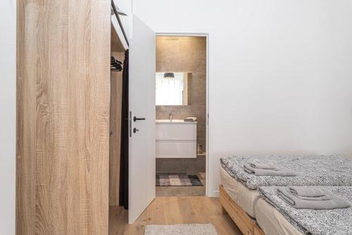 a bedroom with two beds and a bathroom with a sink at Beautiful studio in Antwerp