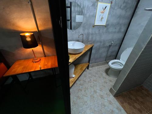 a bathroom with a sink and a toilet at เป่าฟู่เฮ้าส์ Bao Fu's House in Chumphon