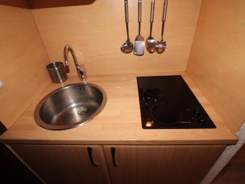- une cuisine avec évier et ustensiles dans l'établissement Studio rénové proche pistes avec balcon - FR-1-502-386, à Tignes