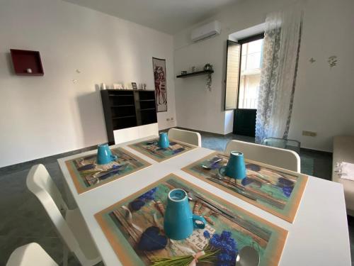 Dimora Zefiro vacanze في جيويوسا ماريا: غرفة طعام مع طاولة مع مزهريات زرقاء عليها