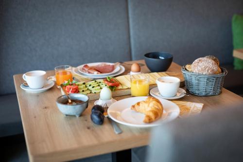 a wooden table topped with plates of food and eggs at Natur Residence Kaiser Hans in Schenna