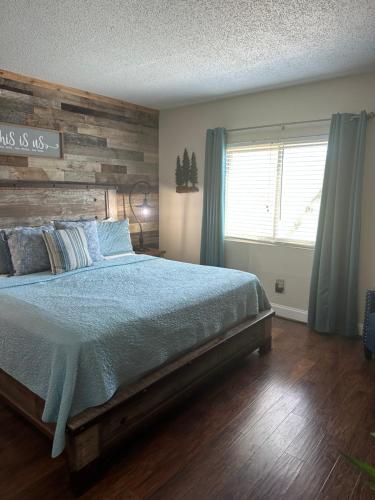 ein Schlafzimmer mit einem Bett und einer Holzwand in der Unterkunft River Place Condos #206 2BD in Pigeon Forge