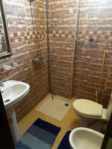 a bathroom with a shower and a toilet and a sink at Residence Ohod in Berrechid