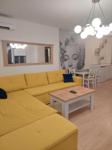 a living room with a yellow couch and a table at Sandanski Apartments Top Center in Sandanski