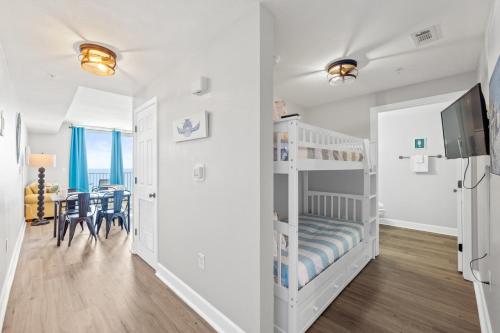 a bedroom with a bunk bed and a dining room at Tidewater Beach Resort #614 by Book That Condo in Panama City Beach