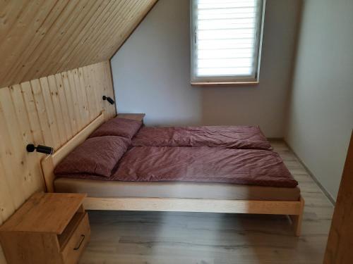 a bed in a small room with a window at Domki Gorczyca in Płaska