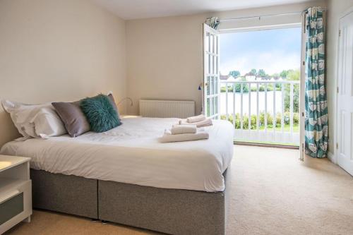 a bedroom with a large bed with a large window at Windrush Lake 88, Waterside in South Cerney