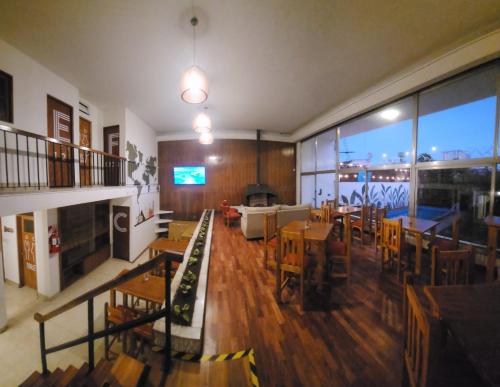 Pachá Hostel Backpack في سالتا: مطعم بطاولات وكراسي وغرفة معيشة