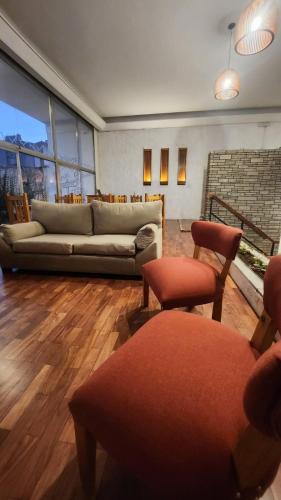 a living room with a couch and two chairs at Pachá Hostel Backpack in Salta