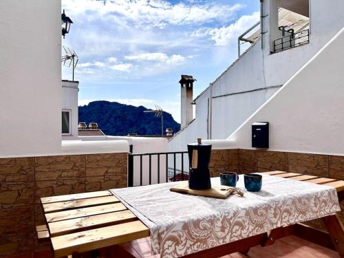 una mesa con un jarrón en la parte superior de un balcón en Jacuzzi en Benaocaz by CadizTime Apartments, en Benaocaz