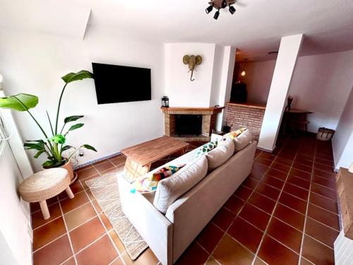 sala de estar con sofá y chimenea en Jacuzzi en Benaocaz by CadizTime Apartments en Benaocaz
