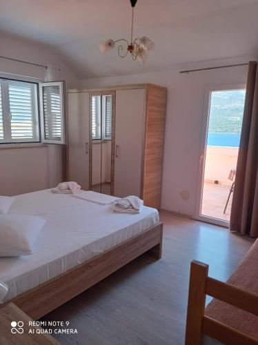 a bedroom with a bed and a view of the ocean at Apartments Panorama in Korčula