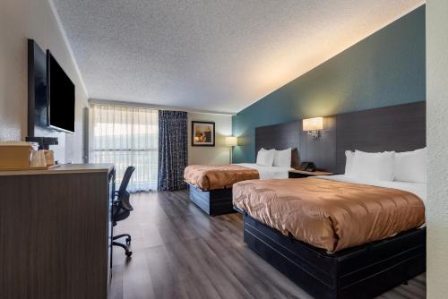 a hotel room with two beds and a flat screen tv at Quality Inn Rock Hill Northeast I-77 in Rock Hill