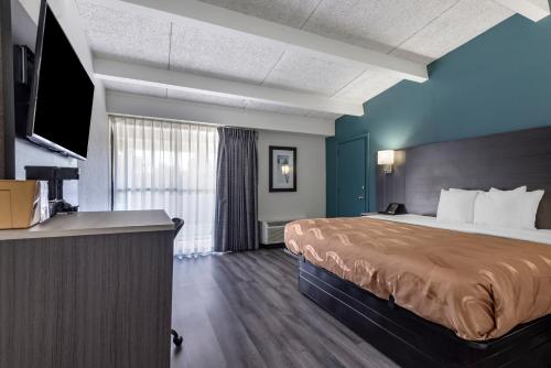 a hotel room with a bed and a flat screen tv at Quality Inn in Rock Hill