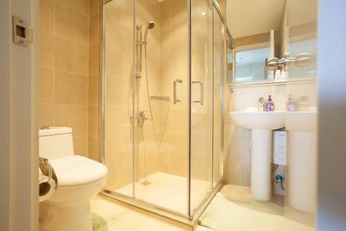 a bathroom with a shower and a toilet and a sink at One BR Penthouse Unit-Knightsbridge Residences in Manila