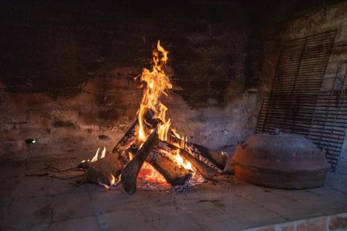 a fire in a brick oven with a pot at Apartmani Lara Modruš-Kuća za odmor in Modruš