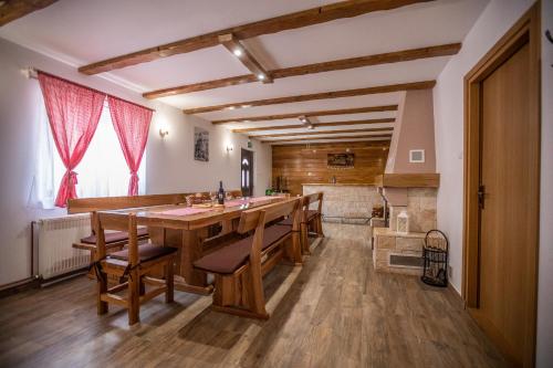 a large dining room with a long table and benches at Apartmani Lara Modruš-Kuća za odmor in Modruš