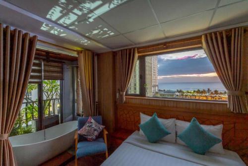 um quarto com uma cama e uma grande janela em Taian Hotel & Apartment em Da Nang