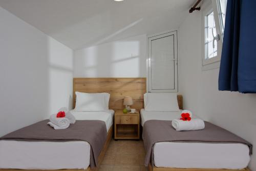 een slaapkamer met 2 bedden en handdoeken bij Elalia Apartments in Chersonissos