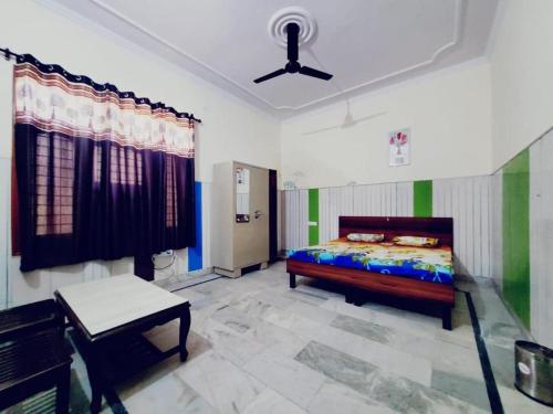 ein Schlafzimmer mit einem Bett und einem Tisch darin in der Unterkunft Royal Oaks Inn in Amritsar