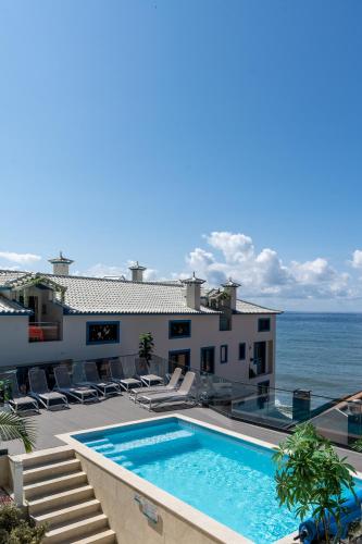 a house with a swimming pool next to the ocean at Mediterrâneo Madeira in São Vicente