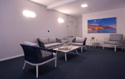 a waiting room with couches and a table and chairs at Mediterrâneo Madeira in São Vicente