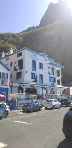a large white building with cars parked in a parking lot at Mediterrâneo Madeira in São Vicente