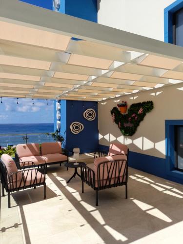 a patio with chairs and a table with a view of the ocean at Mediterrâneo Madeira in São Vicente