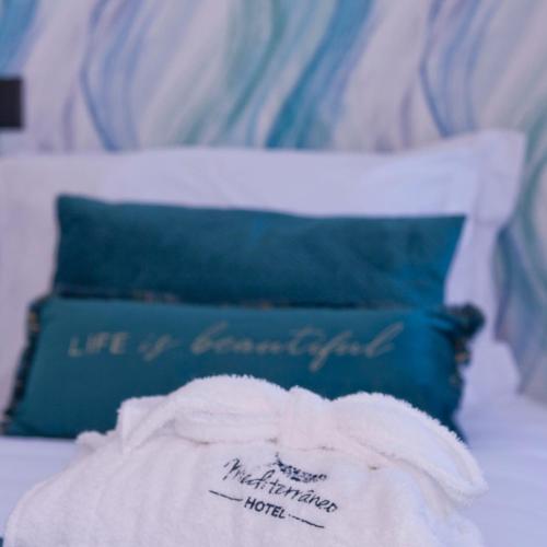 a bed with a blue pillow and a towel at Mediterrâneo Madeira in São Vicente