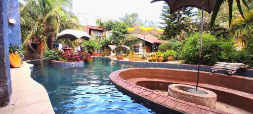 basen z wodą i parasolem na dziedzińcu w obiekcie The quaint cottage with a pool w mieście Naivasha