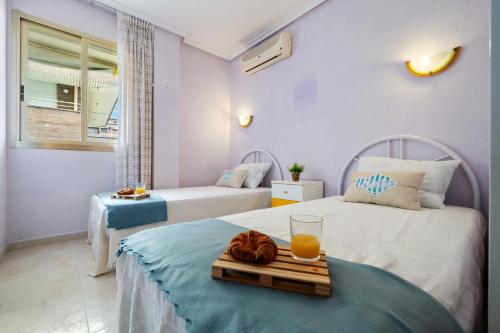 a room with two beds with a tray of orange juice at Paradis Park Apartments in La Pineda