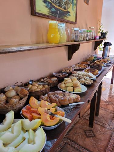 una línea de buffet con diferentes tipos de comida en platos en Pousada Santo Expedito, en Tiradentes